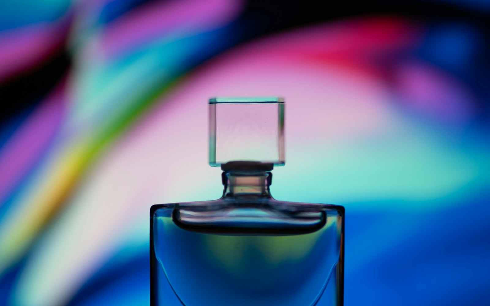Una boccetta di profumo su sfondo colorato
