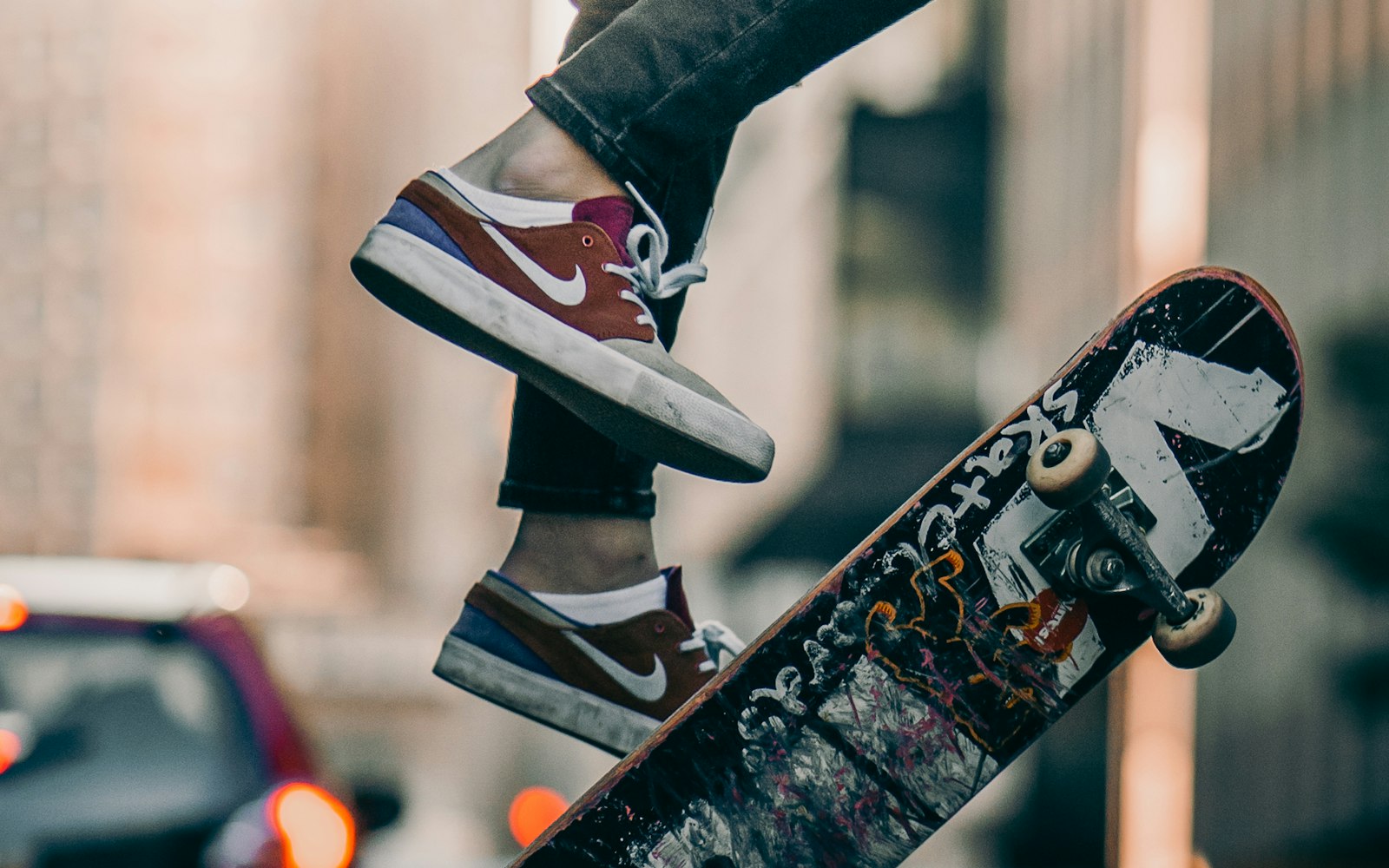 Skateboard e sneakers durante un trick in strada